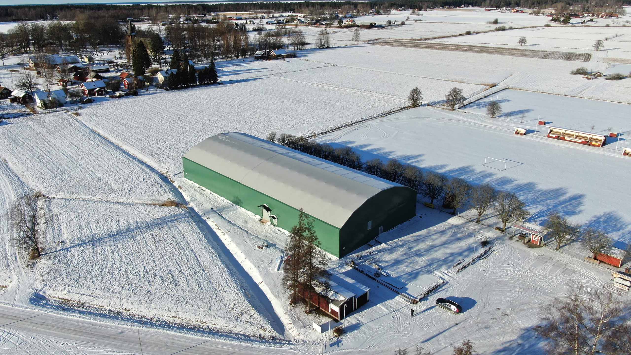 Idrottshallen Gullspång Arena - Sporthall i grön färg med vitt tak i vinterlandskap